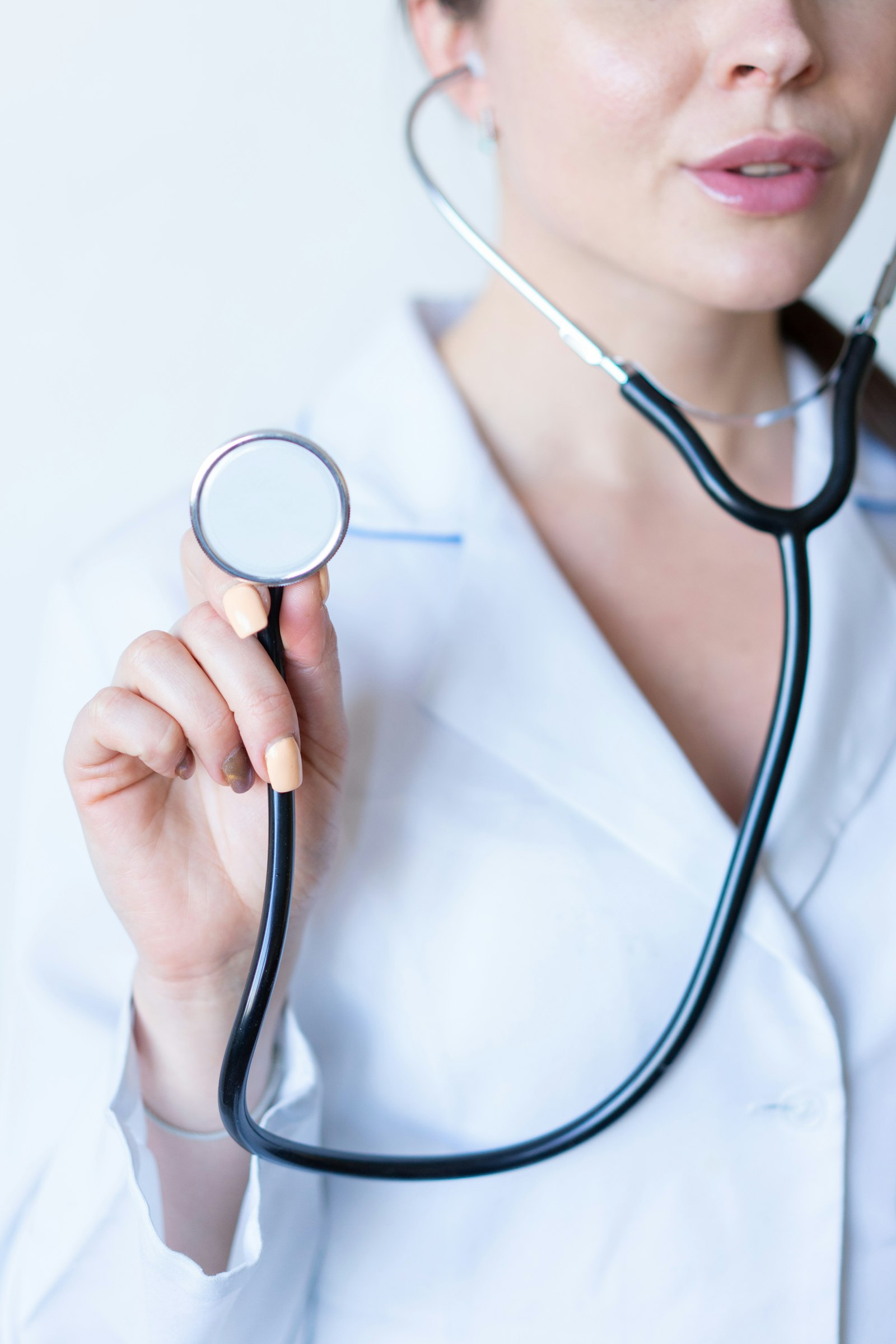 Clinician in a white coat holding a stethoscope