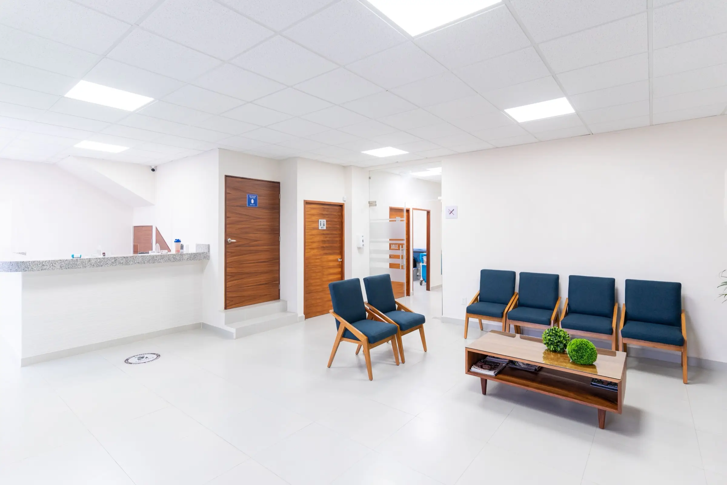 Bright, modern clinic waiting room with blue chairs